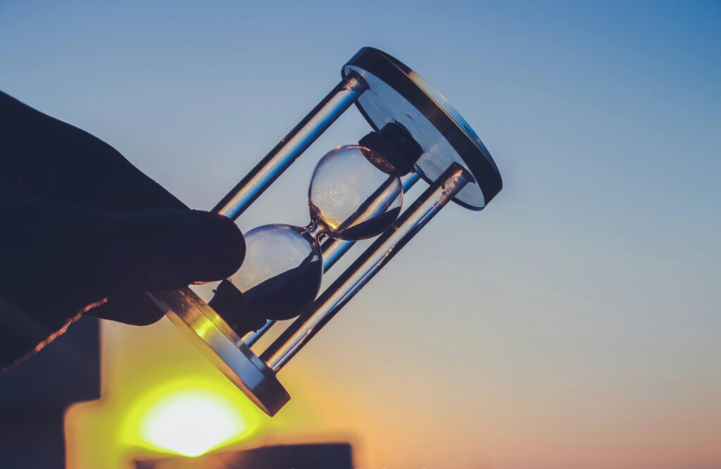 **"A hand holds an hourglass against a stunning sunset, symbolizing the passage of time and fleeting moments. which dedicate about Time Management & Pomodoro Technique"**